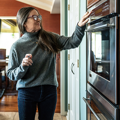 Person turning the kitchen oven on